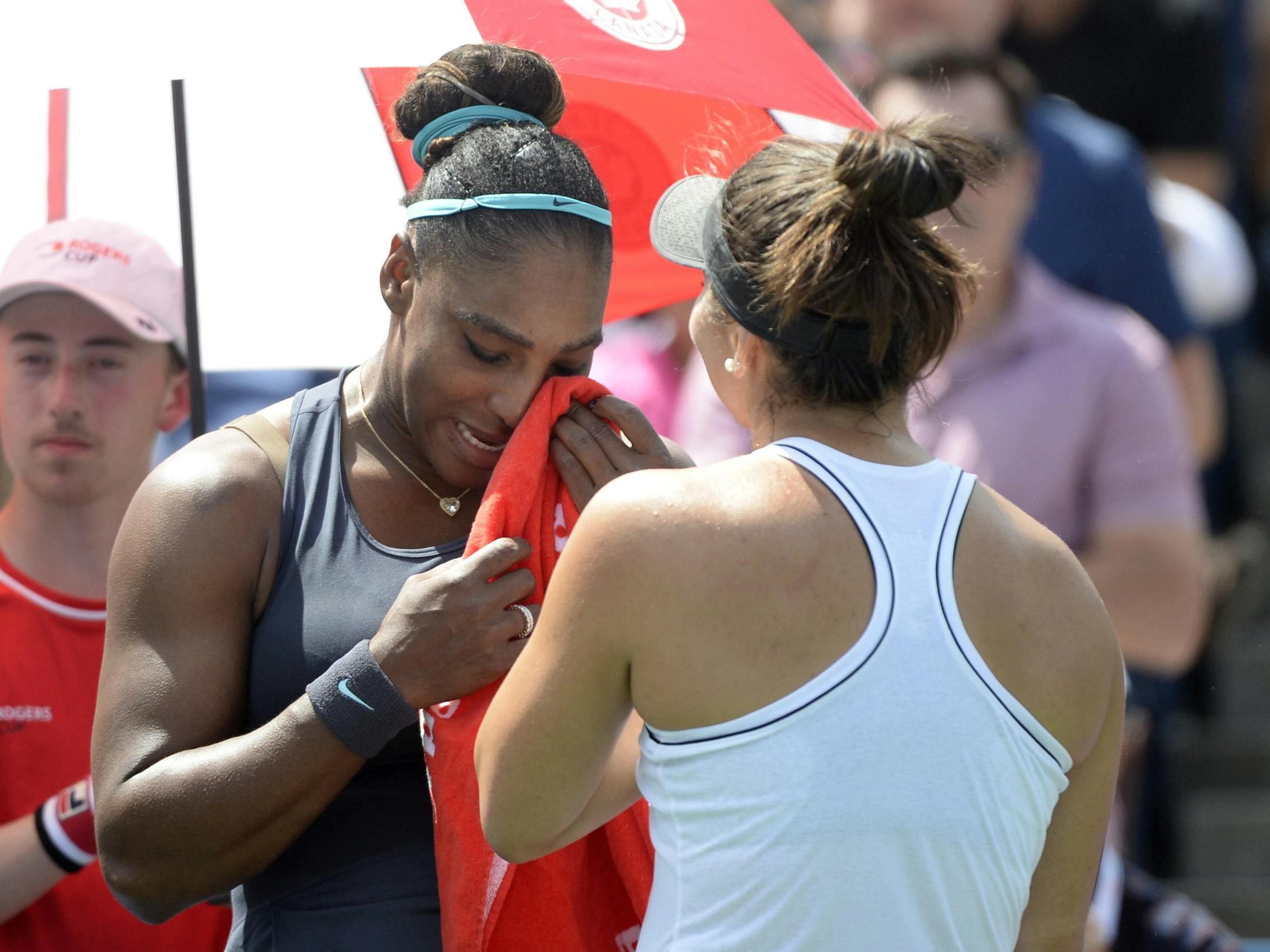 Canada's Bianca Andreescu, right, consoles Serena Williams, of the United States, after Williams had to retire from the final of the Rogers Cup tennis tournament in Toronto, Sunday, Aug. 11, 2019. (Nathan Denette/The Canadian Press via AP)