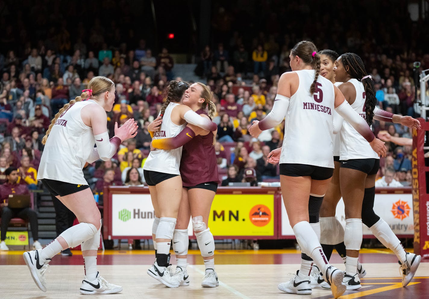 Liberos Zeynep Palabiyik (14) and Kylie Murr (6) hug each other after winning a point in the fourth set Friday, Nov. 10, 2023, at Maturi Pavilion at the University of Minnesota in Minneapolis, Minn. Purdue won 3 sets to 1. ]