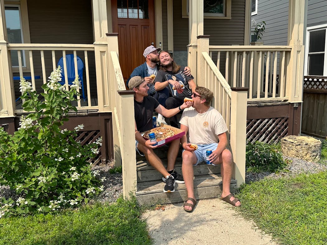 The Denim Boys posed for a photo with hot dogs, beer and pizza on their porch ahead of Uptown Porchfest. From left: Jake Folska, Al Smith, Danny Paulson and Jake Geraghty.