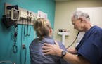 Dr. Michael Kamp examines a patient Thursday at Open Cities Medical Center. The low-income clinic in St. Paul would face major funding losses under th
