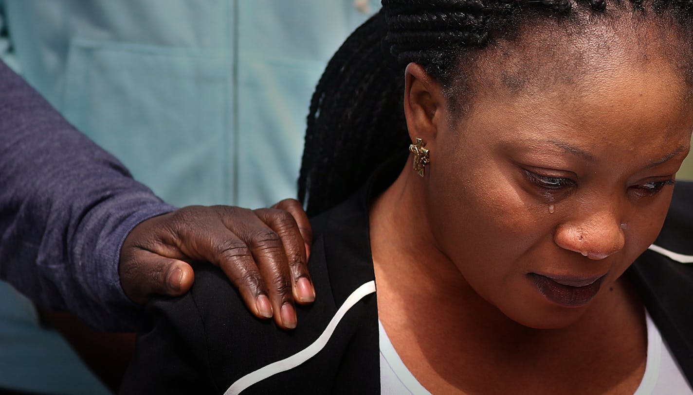 Pierre Collins� wife, Yamah, wept during the vigil. ] JIM GEHRZ � james.gehrz@startribune.com / Crystal, MN / April 18, 2015 / 1:00 PM � BACKGROUND INFORMATION: Liberian immigrant community held a vigil in a park near Barway Collins' apartment building in Crystal.