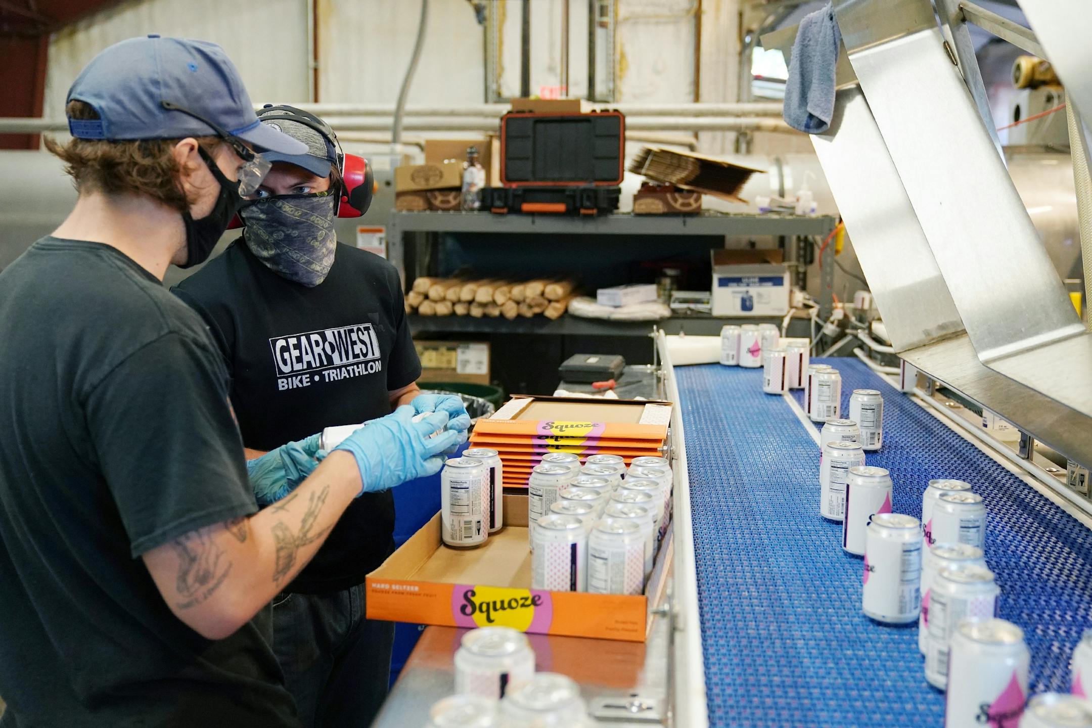 Jesse Roach, left, and Calvin Cruz talked as they ran the canning line for Sociable Cider Werks' Squoze Hard Seltzer Thursday morning in northeast Minneapolis.