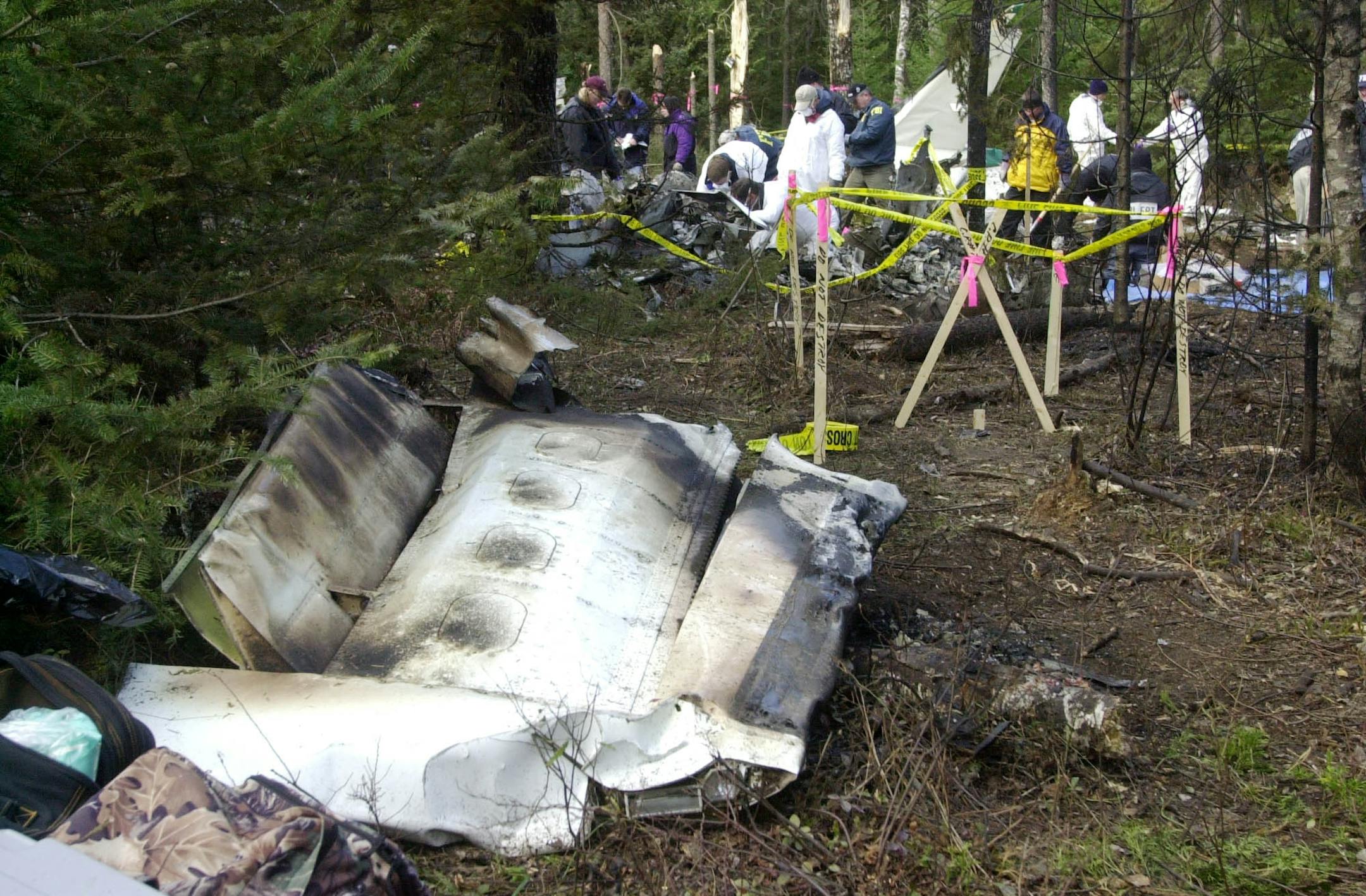 Investigators comb through the wreckage of a twin-engine charter plane that crashed Friday, killing Sen. Paul Wellstone, his wife, daughter, and five others, Sunday, Oct. 27, 2002, in Eveleth, Minn.,
