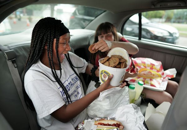 Nevaeh McCave, 12 and Laila Morneau were all smiles after getting a bucket of Sweet Martha Cookies on their final food stop Thursday morning at the fa