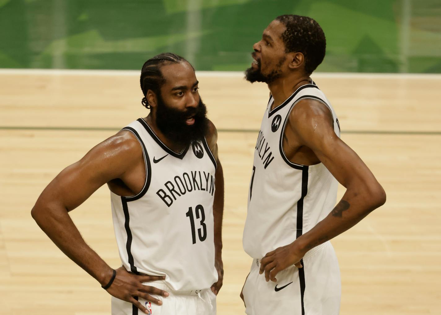 Brooklyn Nets guard James Harden (13) and teammate Kevin Durant talk during the first half of Game 6 of a second-round NBA basketball playoff series against the Milwaukee Bucks, Thursday, June 17, 2021, in Milwaukee. (AP Photo/Jeffrey Phelps)