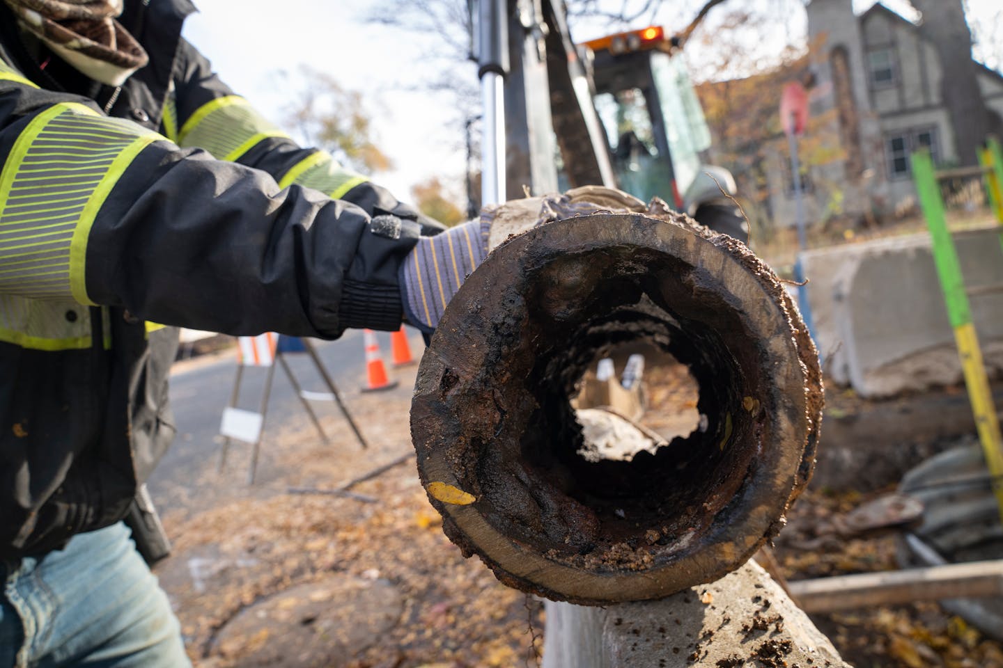 Minneapolis water utility foreman Carlos San Miguel holds a cast iron water main pipe from 1925 that they cut off during the cleaning and lining process, showing the build-up inside, near 47th Ave S and Dowling Street in Minneapolis, Minn. on Friday, Nov. 3, 2023. ] LEILA NAVIDI • leila.navidi@startribune.com