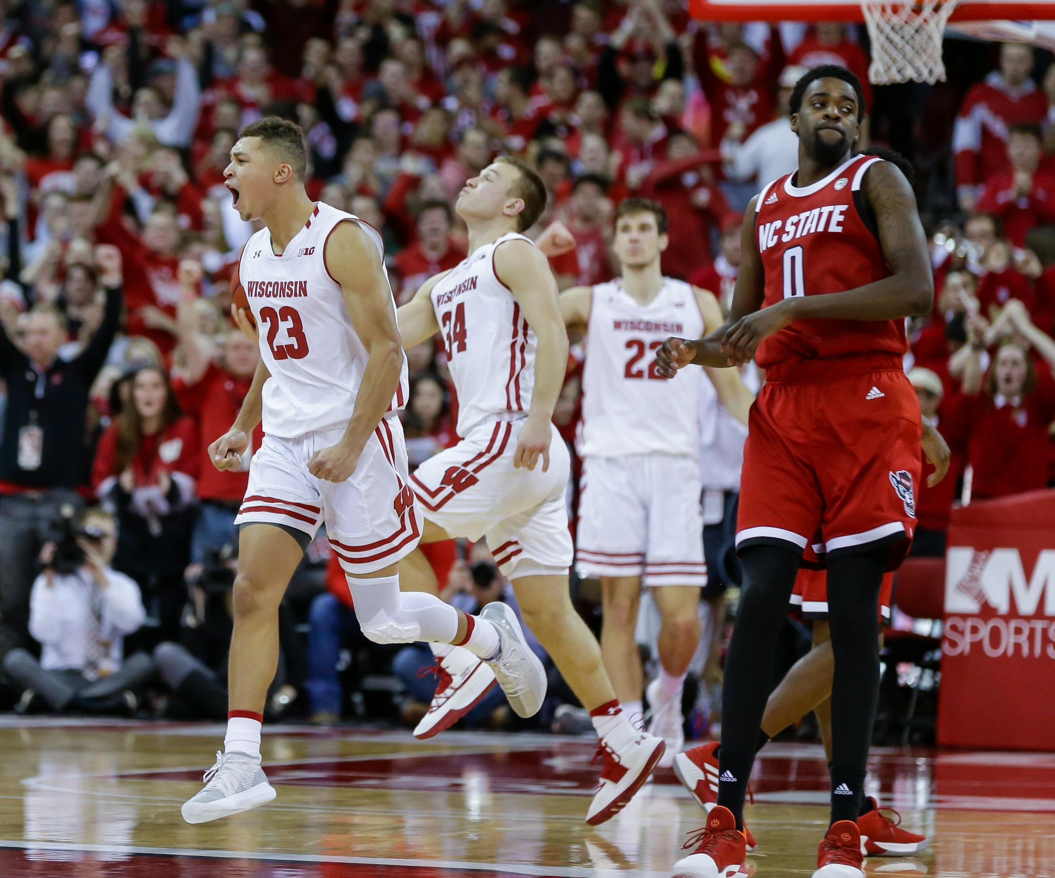 Wisconsin's Kobe King (23), Brad Davison (34) and Ethan Happ (22) celebrate as North Carolina State's DJ Funderburk (0) walks off the court during Wisconsin's 79-75 win in an NCAA college basketball game Tuesday, Nov. 27, 2018, in Madison, Wis. (AP Photo/Andy Manis)