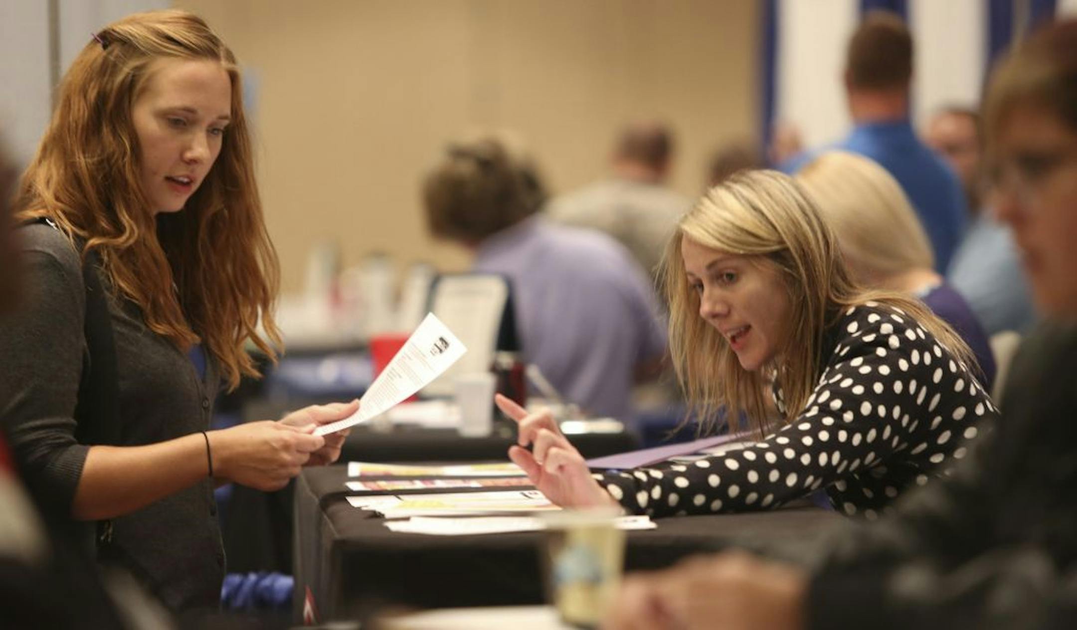 Brittany Paulson, left, of Minneapolis, talked with Kate Fisher, promotions manager for Radio Disney, at a job fair Wednesday at the Minneapolis Convention Center. The 24-year-old Paulson has a part-time job and has been looking for full-time work for a year. Unlike the majority of Minnesotans ages 18 to 24, Paulson can pay for an apartment of her own.