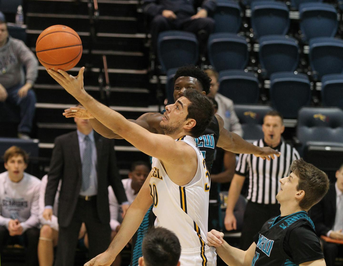 Alihan Demir, center, of Drexel goes through the UNC Wilmington defense for a basket during the 1st half on Feb. 7, 2019.