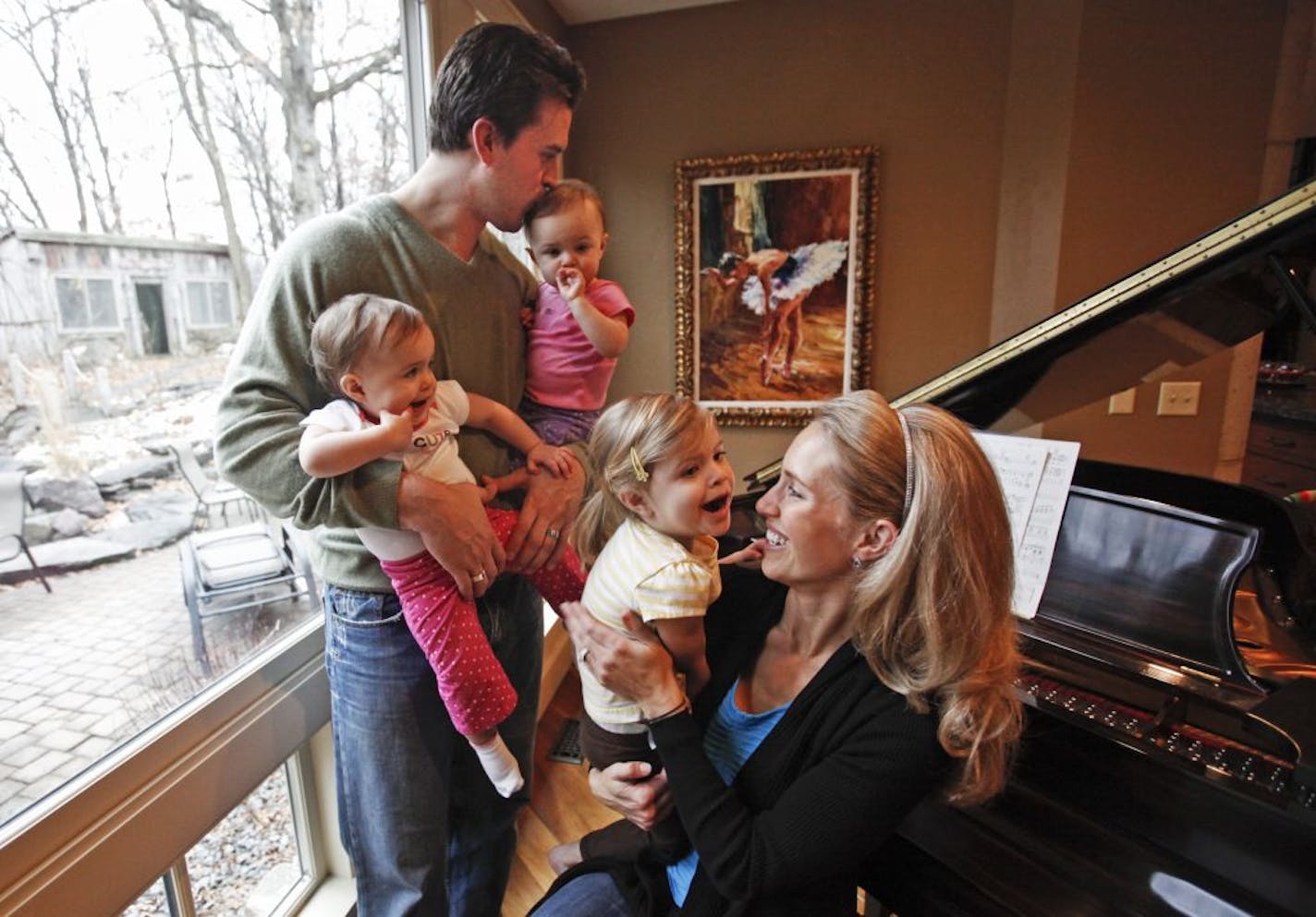 After posing for a family portrait, former Gophers and NFL tight end Ben Utecht kissed his daughter Amy, 1, while also holding Amy's twin sister Katriel, 1, as Utecht's wife Karyn held their daughter Elleora, 2 1/2 at their home Tuesday, Dec. 13, 2011 in Lakeville.