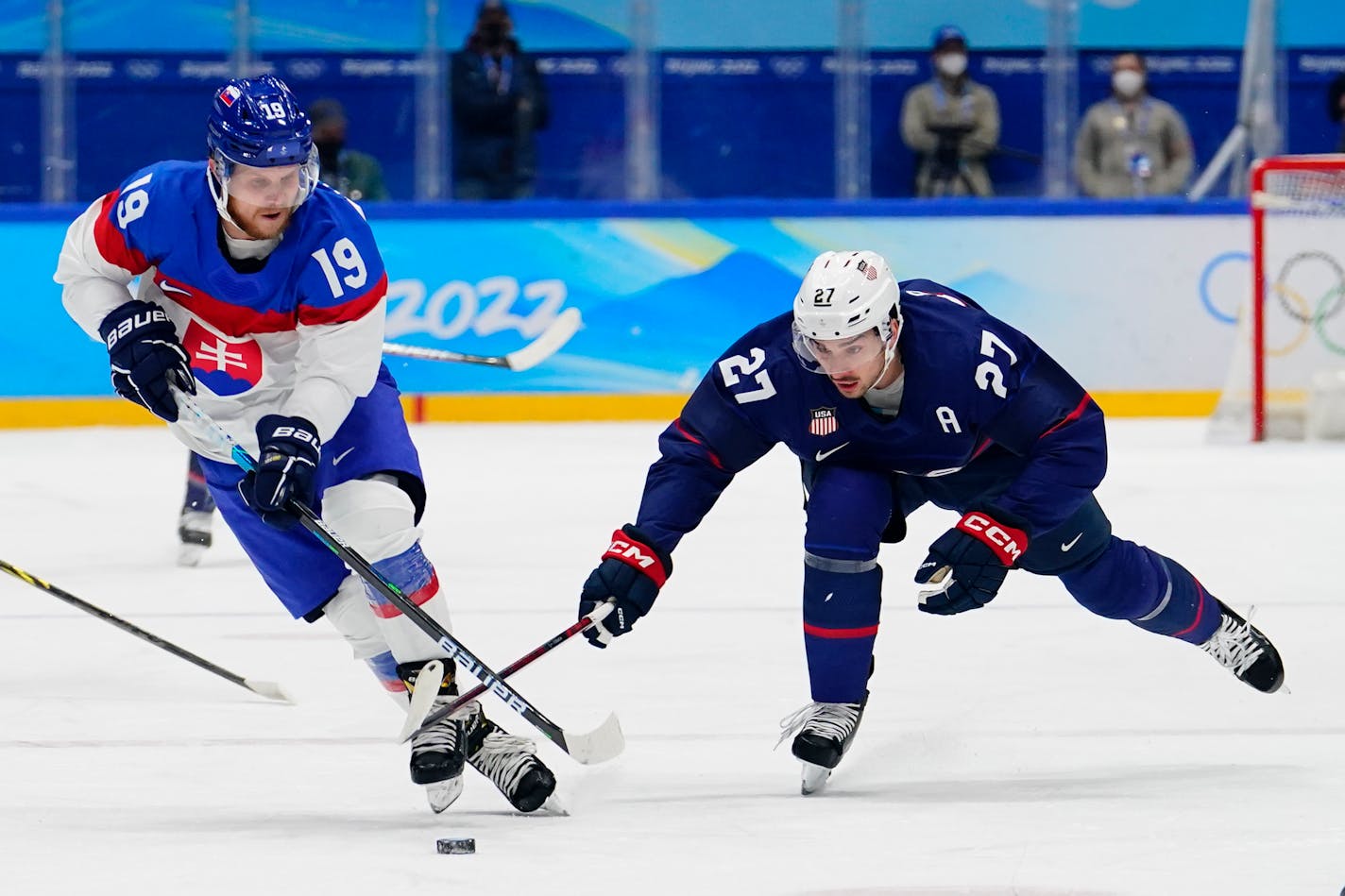 United States' Noah Cates (27) tries to stop Slovakia's Michal Kristof (19) during a men's quarterfinal hockey game at the 2022 Winter Olympics, Wednesday, Feb. 16, 2022, in Beijing. (AP Photo/Matt Slocum)