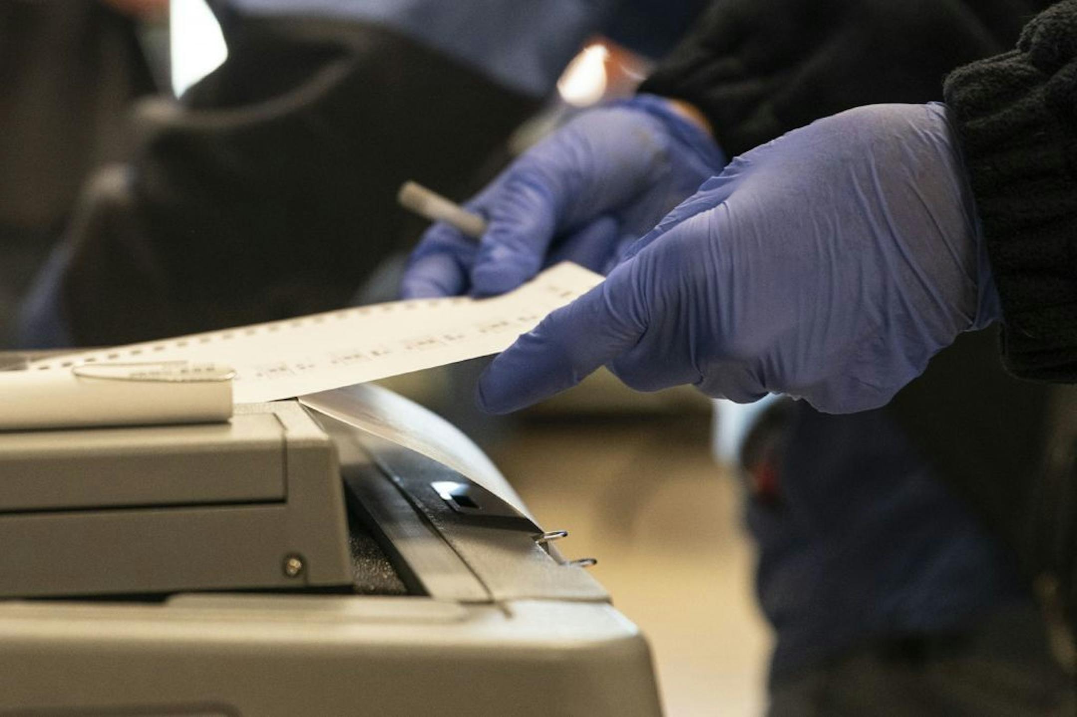 A voter submitted their ballot while wearing latex gloves at First United Methodist Church in Duluth on Tuesday morning.