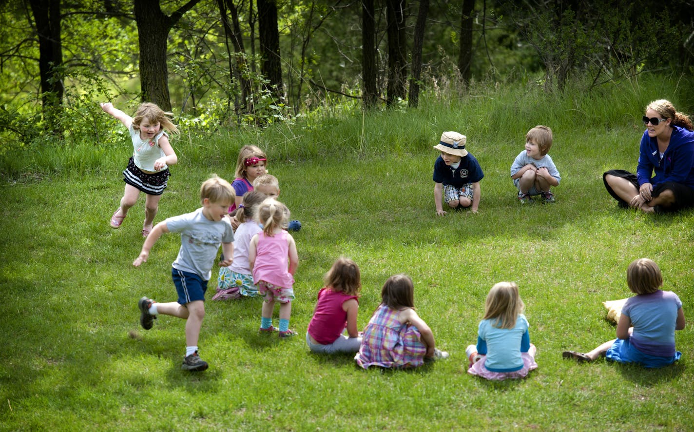 Afton Preschool student teacher Krista Friberg, right, had students sit in a circle and play duck, duck, gray duck, Tuesday, May 15, 2012. The preschool is closing down May 24. ] GLEN STUBBE * gstubbe@startribune.com EDS: We may show student faces but not use students names.