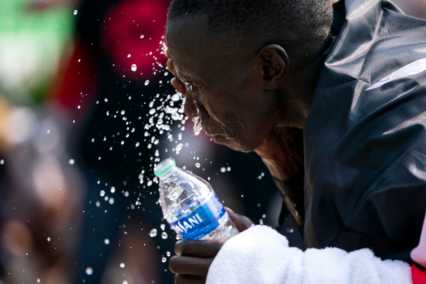 Elisha Barno, 37, pours water on himself after finishing in first place.