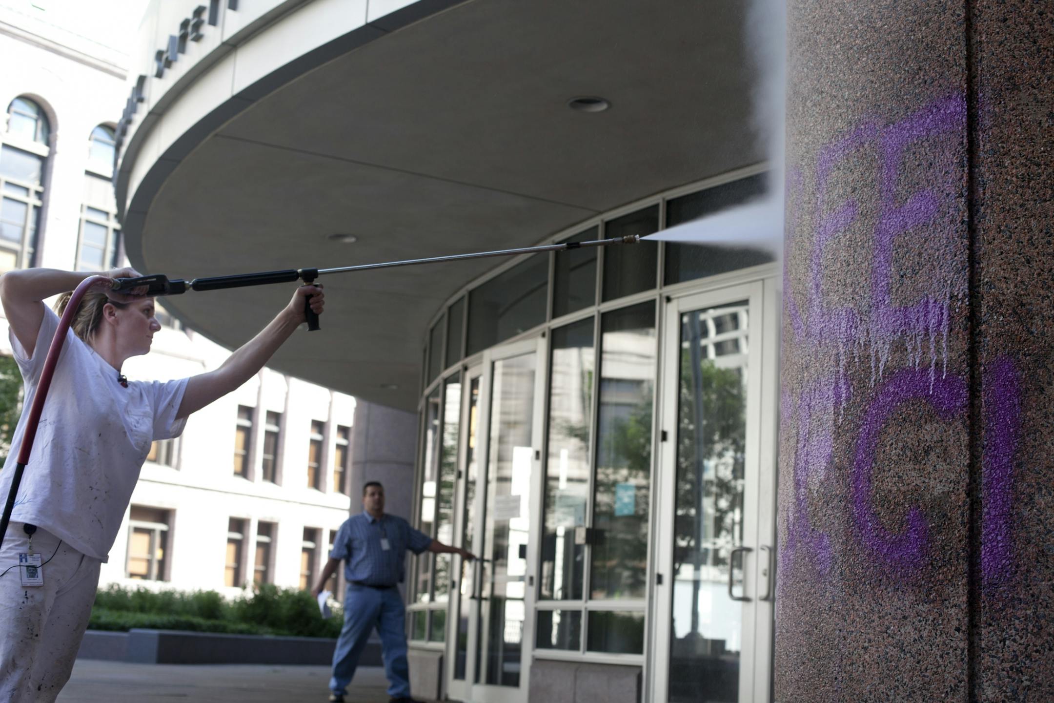 Chari Jenson, 38, employee of Universal Painting and Drywall erases Graffiti that reads "Free CeCi Now!" from the sheriff's jail located at 401 S. 4th St. Minneapolis, Minn. on Tuesday July 5, 2012.