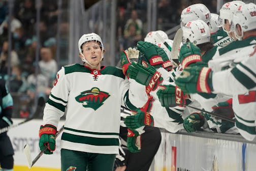 Minnesota Wild center Rem Pitlick, center, greets teammates at the bench after he scored a goal against the Seattle Kraken in the first period of an NHL hockey game, Saturday, Nov. 13, 2021, in Seattle. (AP Photo/Ted S. Warren) ORG XMIT: MER674bda95f49b88e0ae946941739ba