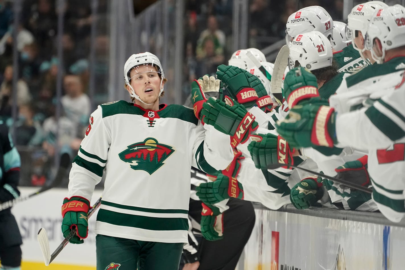 Minnesota Wild center Rem Pitlick, center, greets teammates at the bench after he scored a goal against the Seattle Kraken in the first period of an NHL hockey game, Saturday, Nov. 13, 2021, in Seattle. (AP Photo/Ted S. Warren) ORG XMIT: MER674bda95f49b88e0ae946941739ba