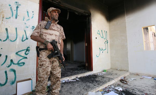 2012: A Libyan military guard stands in front of one of the U.S. Consulate's burnt out buildings.