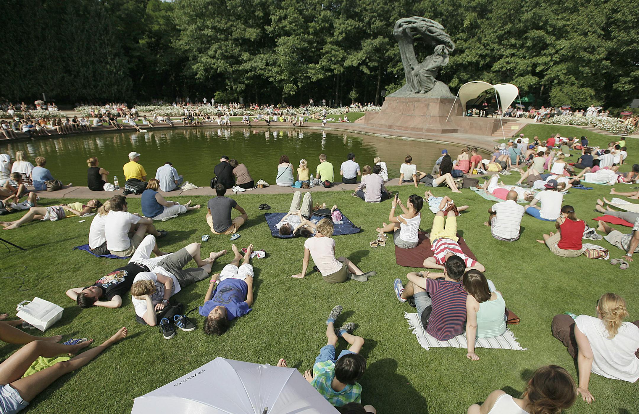 People gathered for a free concert next to a monument to the Polish composer, Chopin, in Lazienki Park.