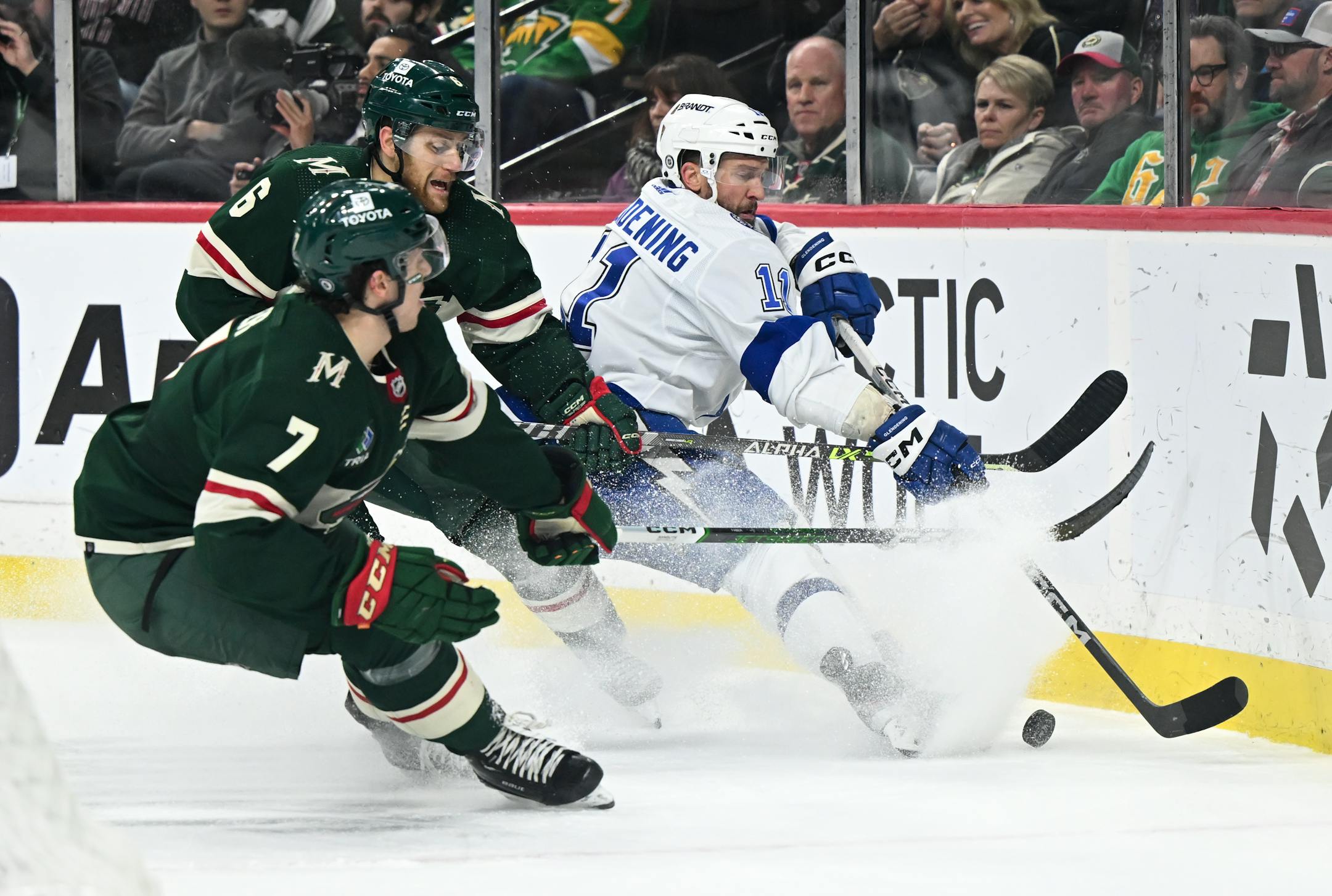 Minnesota Wild defenseman Brock Faber (7), defenseman Dakota Mermis (6) and Tampa Bay Lightning center Luke Glendening (11) battle for the puck during the second period Thursday, Jan. 4, 2024 at Xcel Energy Center in St. Paul, Minn.. ] AARON LAVINSKY • aaron.lavinsky@startribune.com