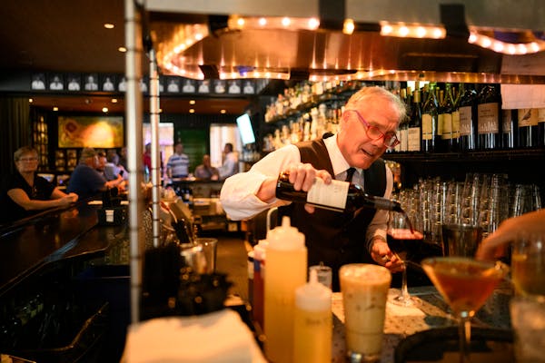 Bartender Patrick Tierney, pouring a glass of wine at Manny’s Steakhouse in Minneapolis, said he went into the restaurant business to win over custo