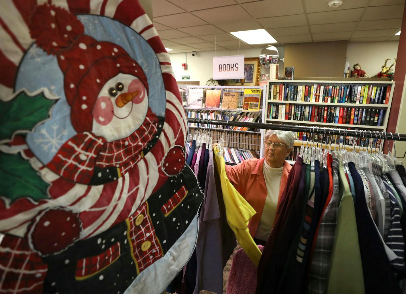 A woman peruses through the selections at a thrift shop.