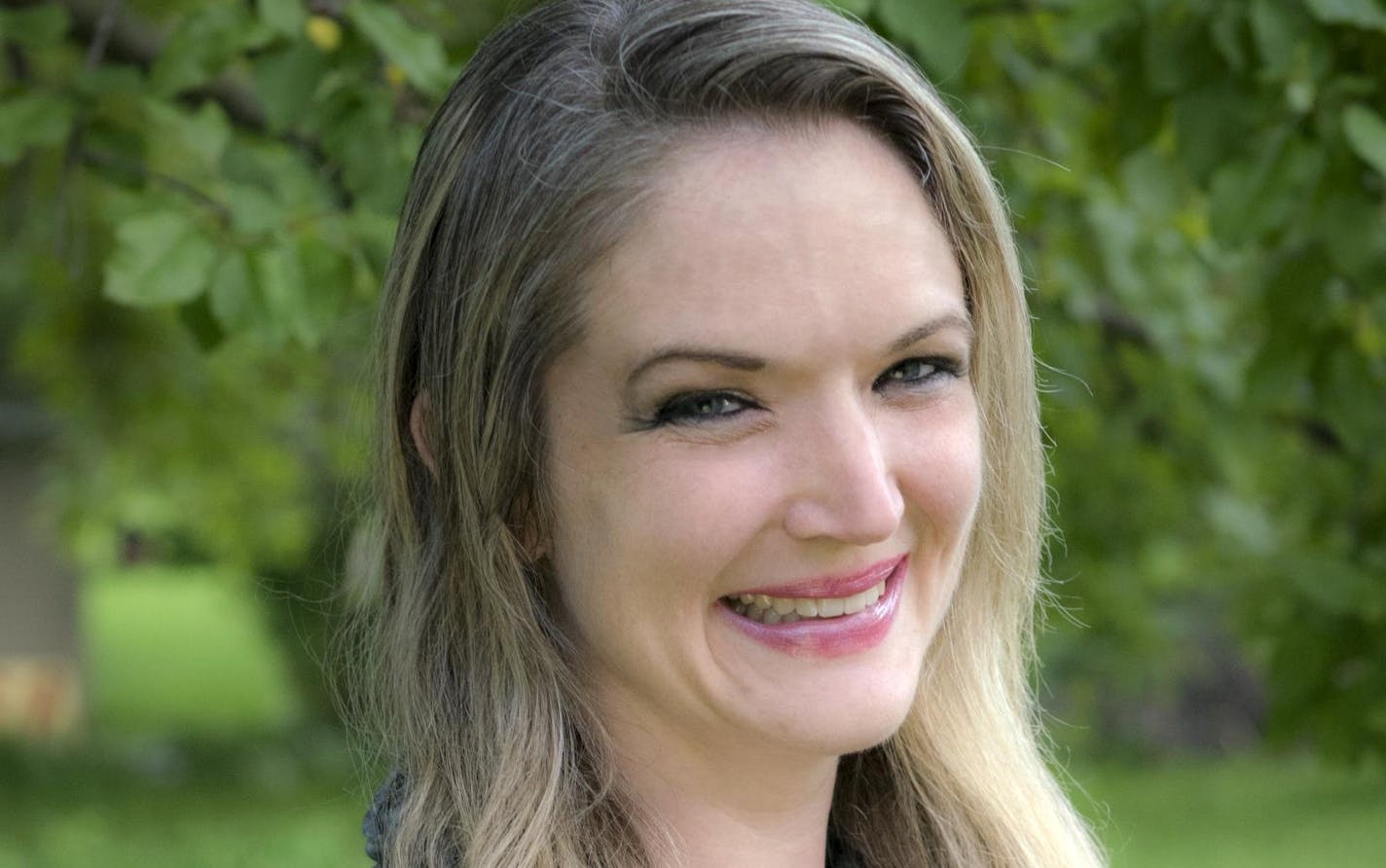 Portrait of Rochester City Council Member Molly Dennis against background of greenery.