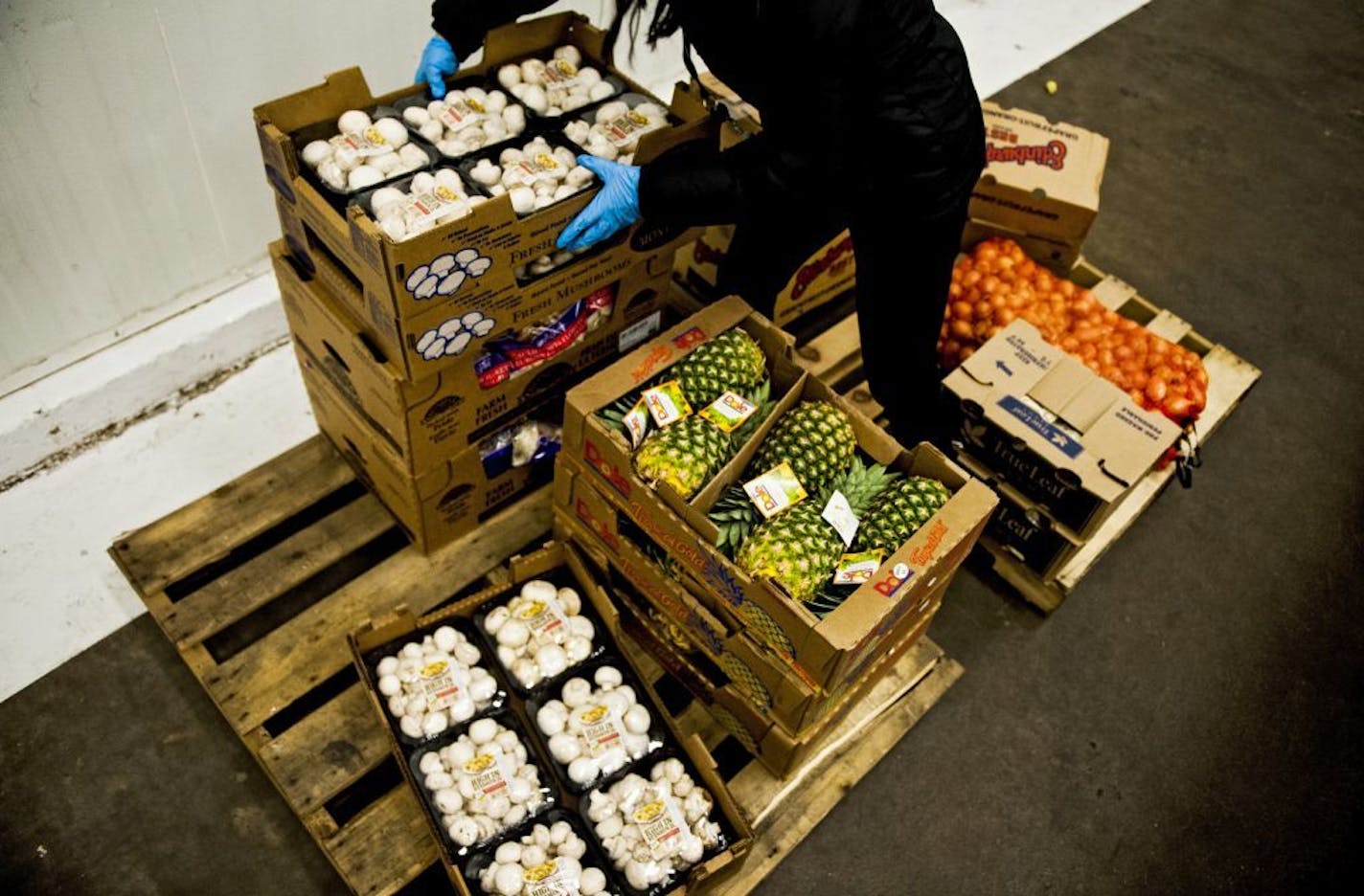 Rebecca Qian grabs a crate of fresh mushrooms while packing food bags for a research trial that provides appropriate food, doctor referrals, diabetes education and regular blood sugar checks, at the Houston Food Bank, in Houston, Jan 25, 2016. Inconsistent access to food can worsen diabetes, and so can the poor nutritional offerings at the pantries many low-income people must rely on.