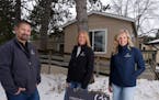 Real estate agents Nate Campion, Tricia Anderson, and Carrie Gibbs with Century 21 Moline Realty stand for a portrait outside a manufactured home Camp