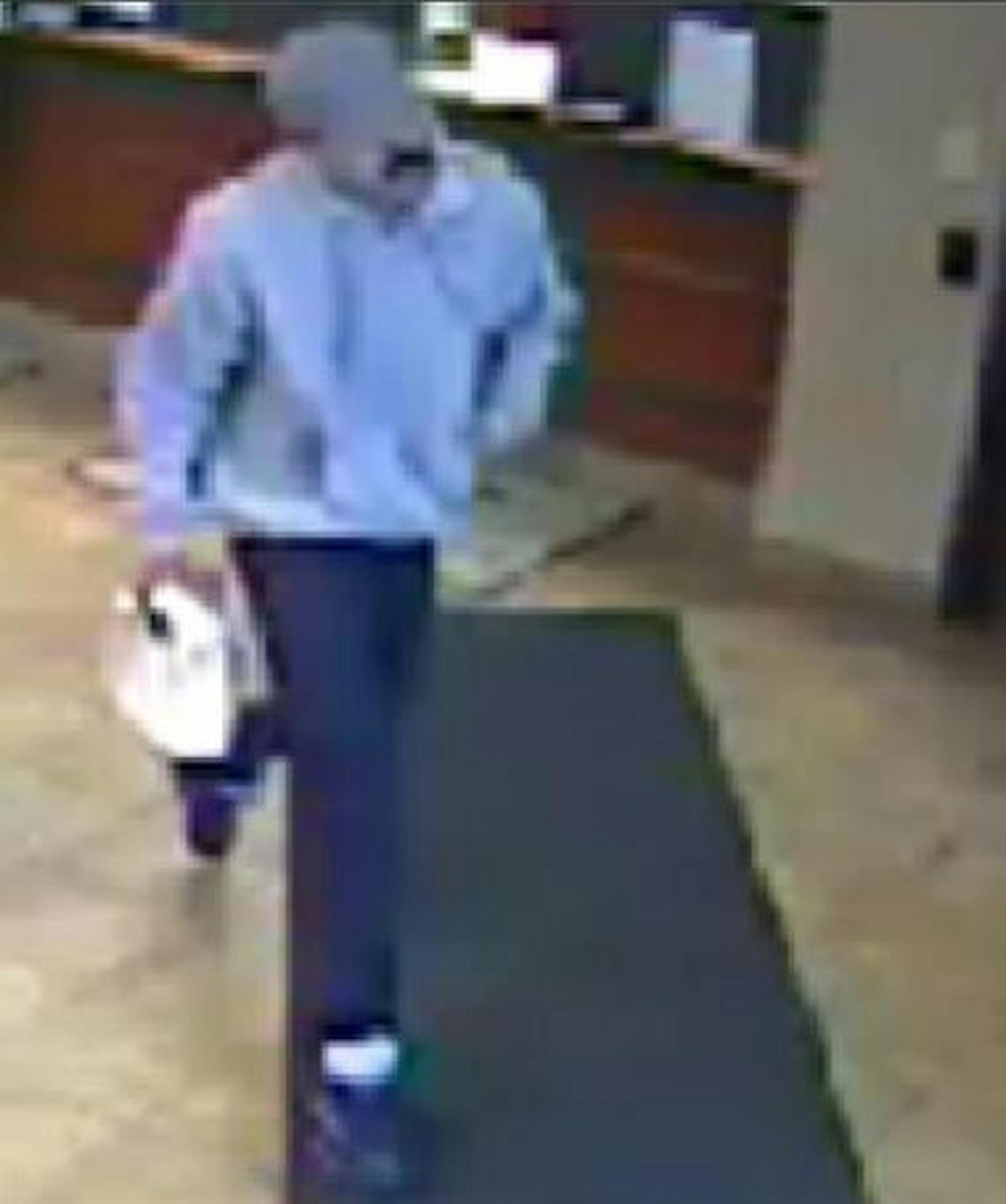 The robber's black, fake mustache can be seen in a surveillance photo taken as he robbed a credit union. Andrew Fogan has been charged with the robbery.