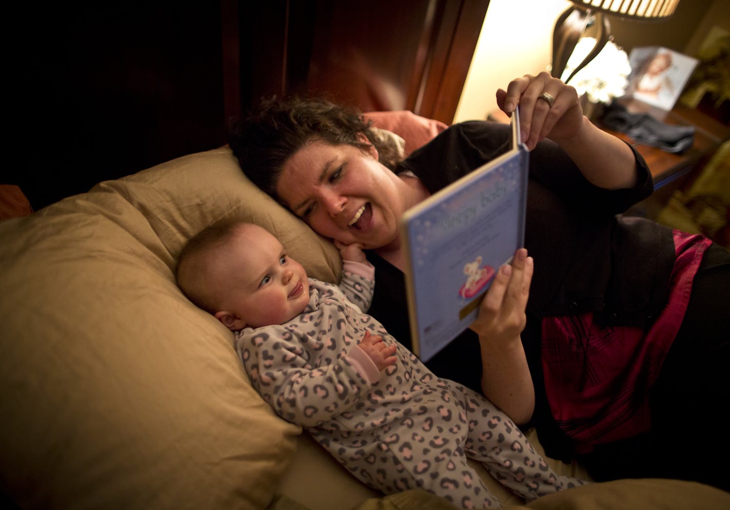Andrea Pedersen laughed as her daughter Anna got a tight grip on her face while they read books at bedtime at home on Thursday, March 7, 2013, in Rochester, Minn. Last year, when she was pregnant, Andrea Pedersen was invited to take part in an experiment at the Mayo Clinic, where she works. She took home a fetal monitor to listen to the baby's heartbeat at home, and did one prenatal visit by Skype. ] (RENEE JONES SCHNEIDER * reneejones@startribune.com)
