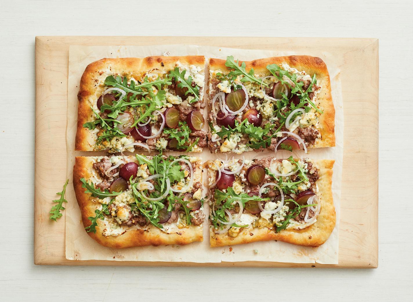 From The Big Book of Pizza by Maile Carpenter and the editors of Food Network Magazine (Hearst Home, $25.00) Sausage with Arugula and Grapes.