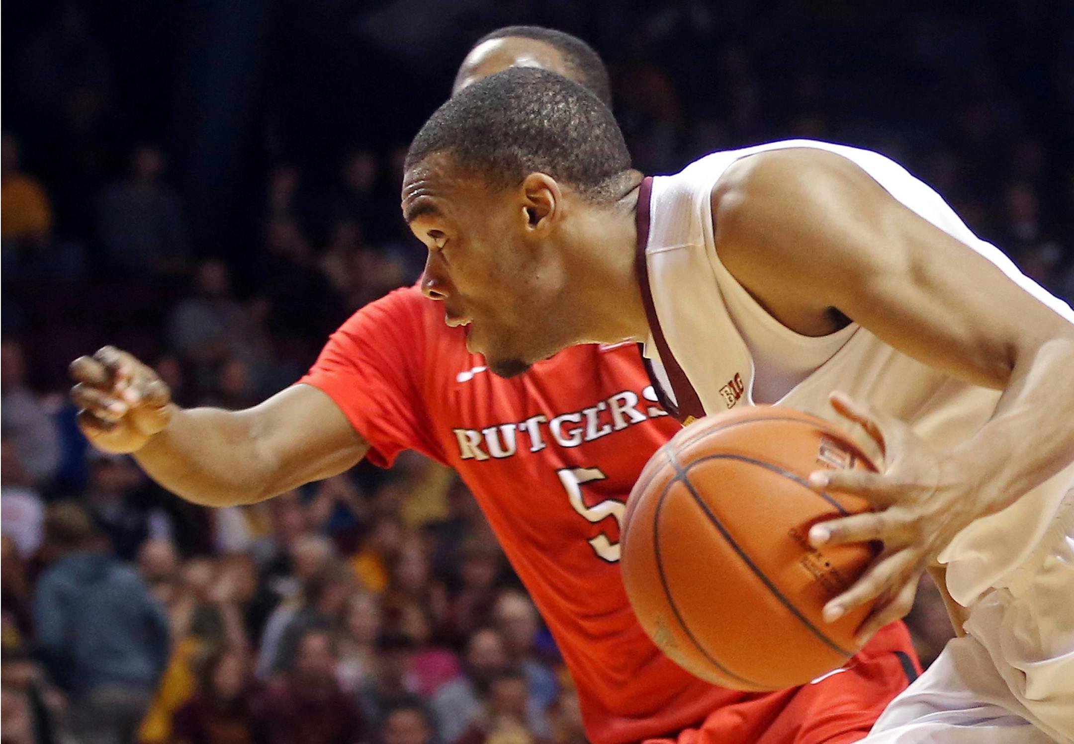 Minnesota�s Andre Hollins, right, drives around Rutgers�s Mike Williams in the second half of an NCAA college basketball game, Saturday, Jan. 17, 2015, in Minneapolis. Hollins led Minnesota with 31 points in their 89-80 win. (AP Photo/Jim Mone)