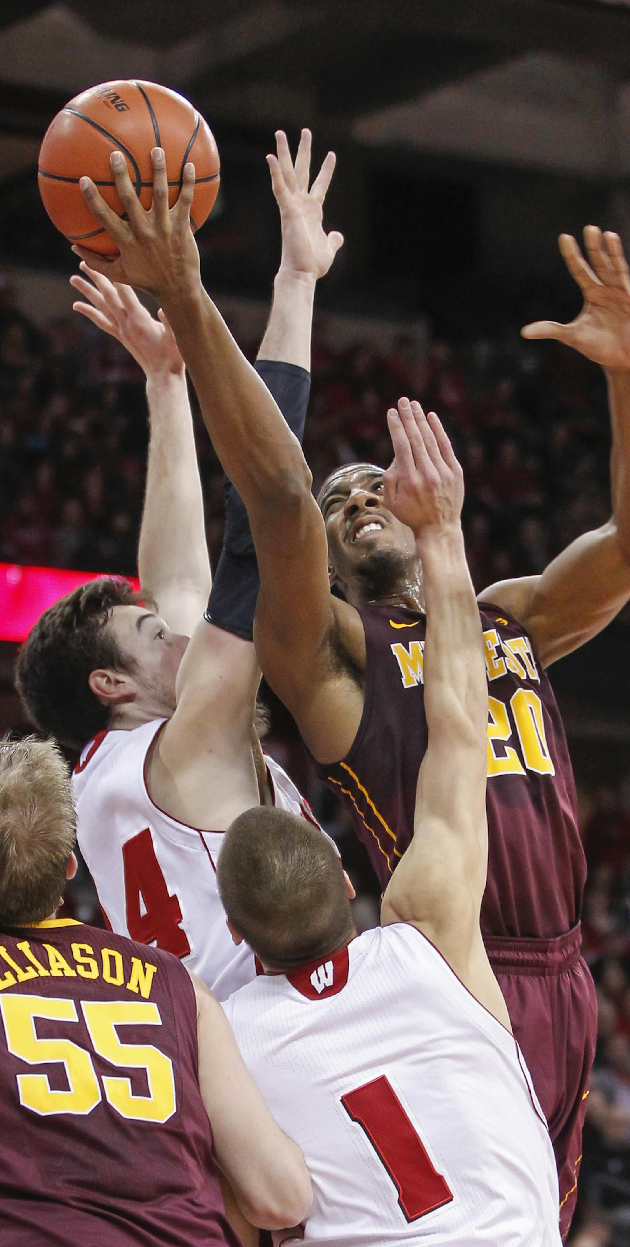 Minnesota's Austin Hollins (20) shoots between Wisconsin's Frank Kaminsky and Ben Brust (1) during the first half of an NCAA college basketball game Thursday, Feb. 13, 2014, in Madison, Wis. (AP Photo/Andy Manis)