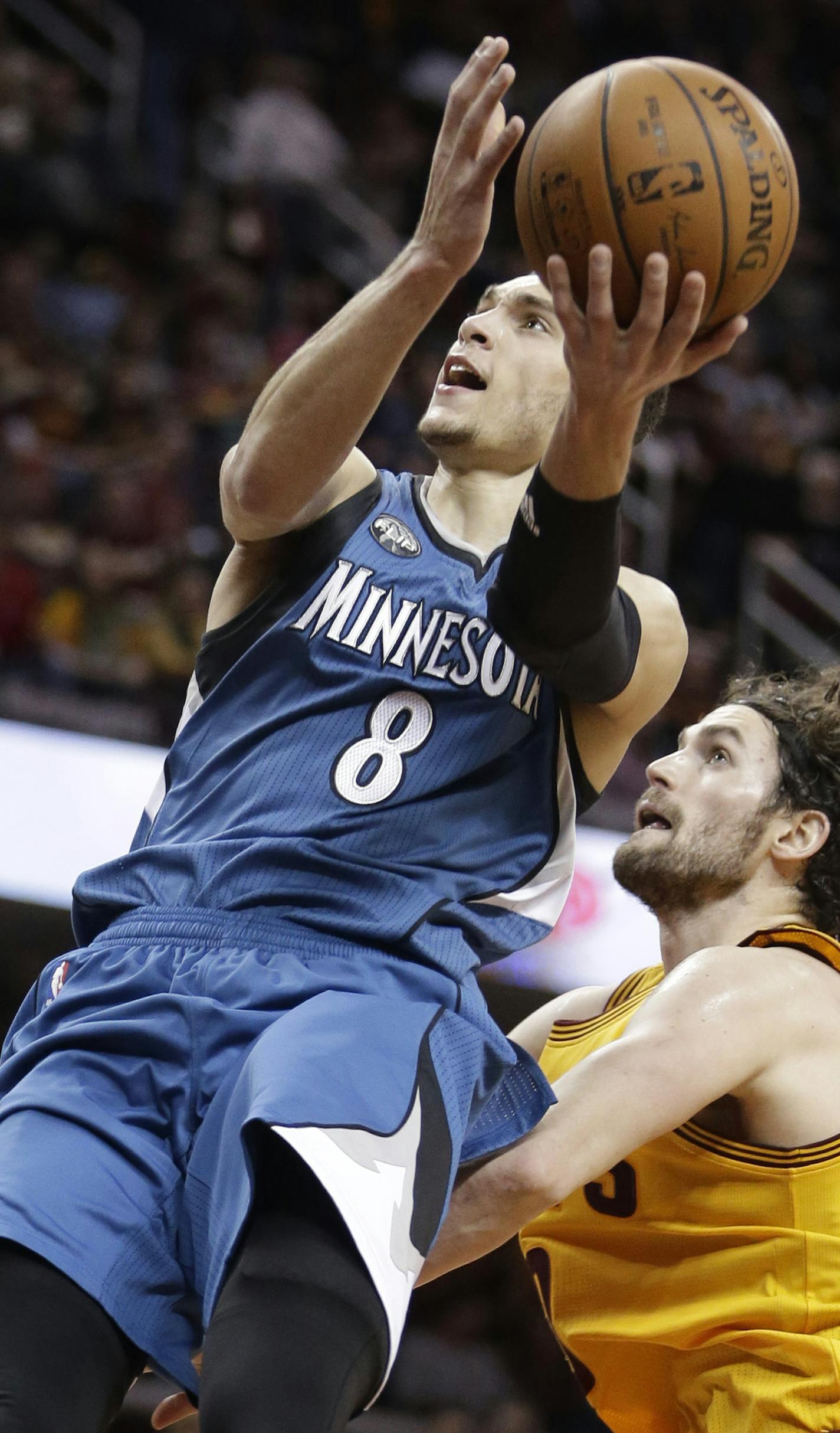 Minnesota Timberwolves' Zach LaVine (8) shoots over Cleveland Cavaliers' Kevin Love (0) in the second half of an NBA basketball game Monday, Jan. 25, 2016, in Cleveland. (AP Photo/Tony Dejak) ORG XMIT: MIN2016012818143852