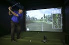 Gary Greenquist, the store's own PGA Teaching Pro, prepared to tee off on a simulator that replicates the course at Hazeltine National. ] JEFF WHEELER