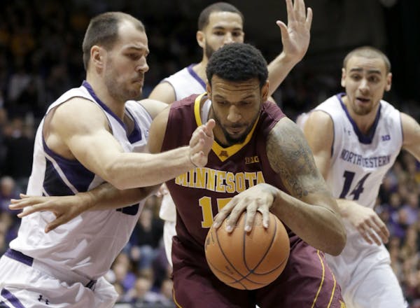 Minnesota forward Maurice Walker, right, controls the ball against Northwestern's Nikola Cerina, left, Drew Crawford, top, and Tre Demps during the fi