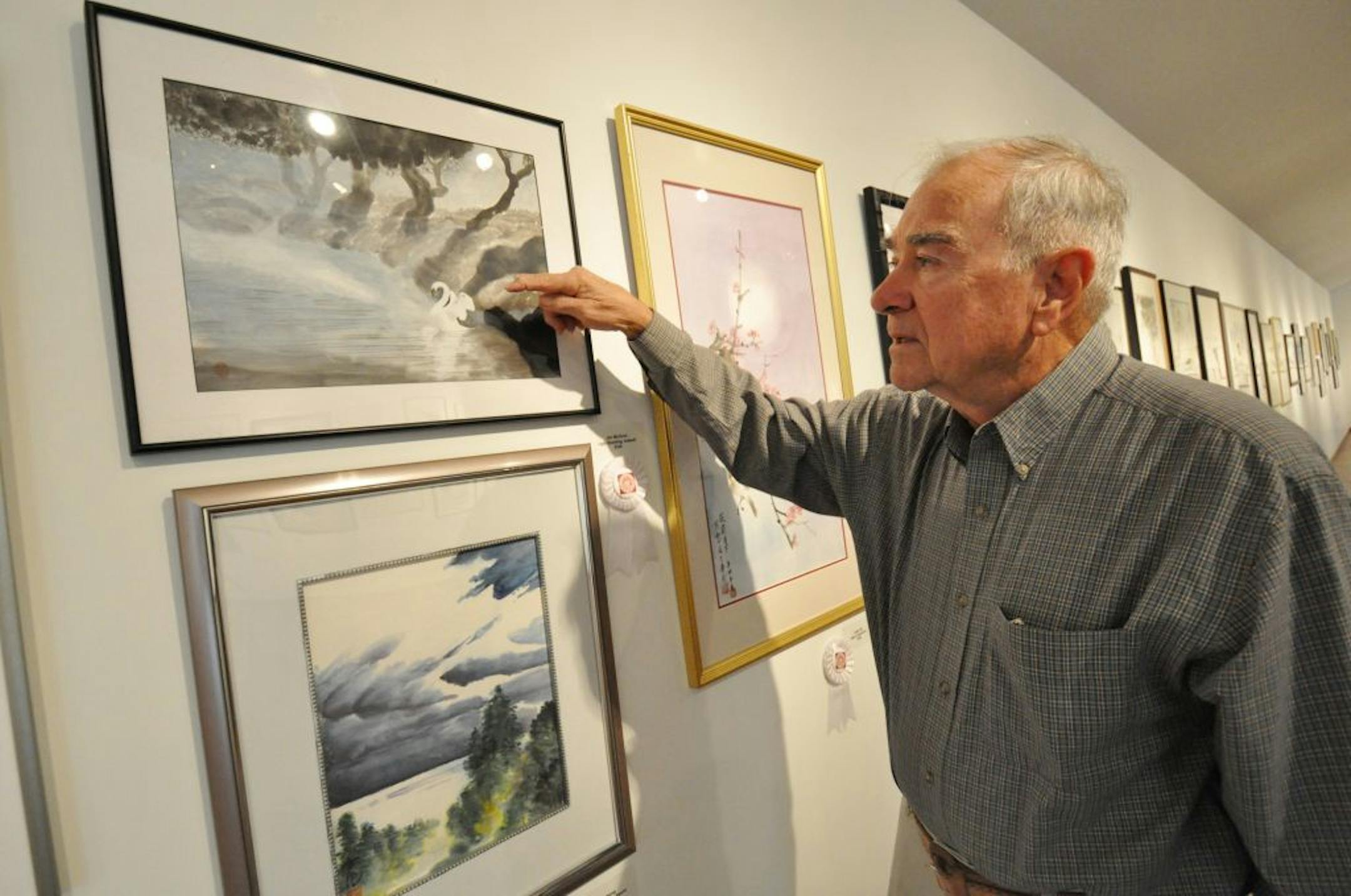 Jim McGuire of Rosemount pointed out detail in his painting (entitled "Ugly Duckling, Indeed!"), one of the pieces featured in the annual national Sumi-e Society of America juried exhibition currently on display at the Burnsville Performing Arts Center gallery.