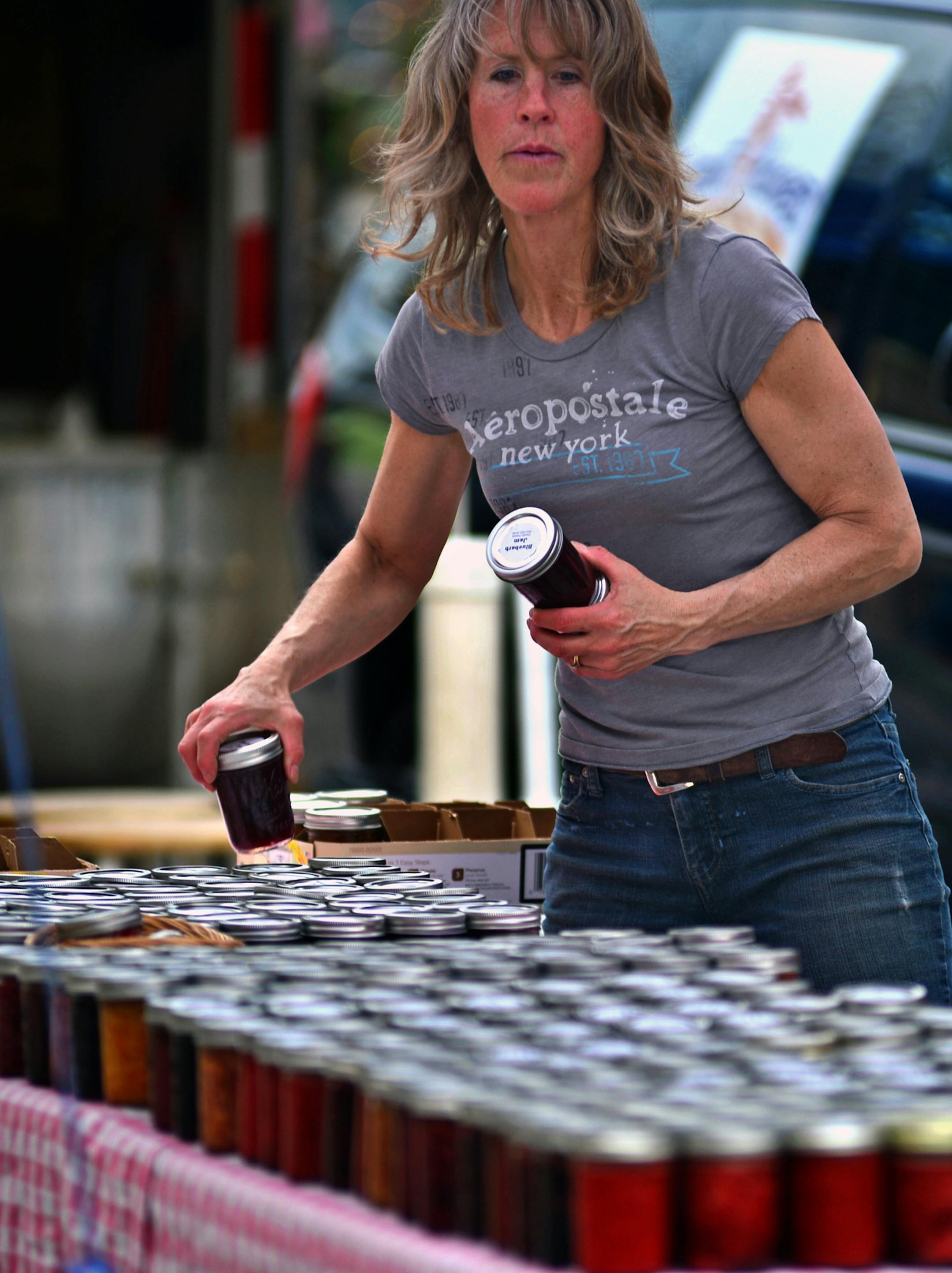 Deb Hoen, of Family Farms in Delano put out jars of fruit preserves, she produces maple syrup and fruit preserves and jams on her farm growing all of the ingredients .] Farmers Market in Excelsior on Water Street Richard.Sennott@startribune.com Richard Sennott/Star Tribune Excelsior Minn. Thursday 5/08/2014) ** (cq)