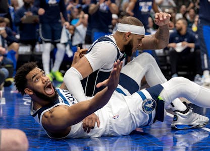 The Wolves' Karl-Anthony Towns, left, reacts during a play while defended by the Mavericks' Daniel Gafford in the second quarter of Game 4 of the NBA 