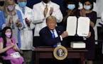 President Donald Trump holds up an executive order after delivering remarks on healthcare at Charlotte Douglas International Airport, Thursday, Sept. 