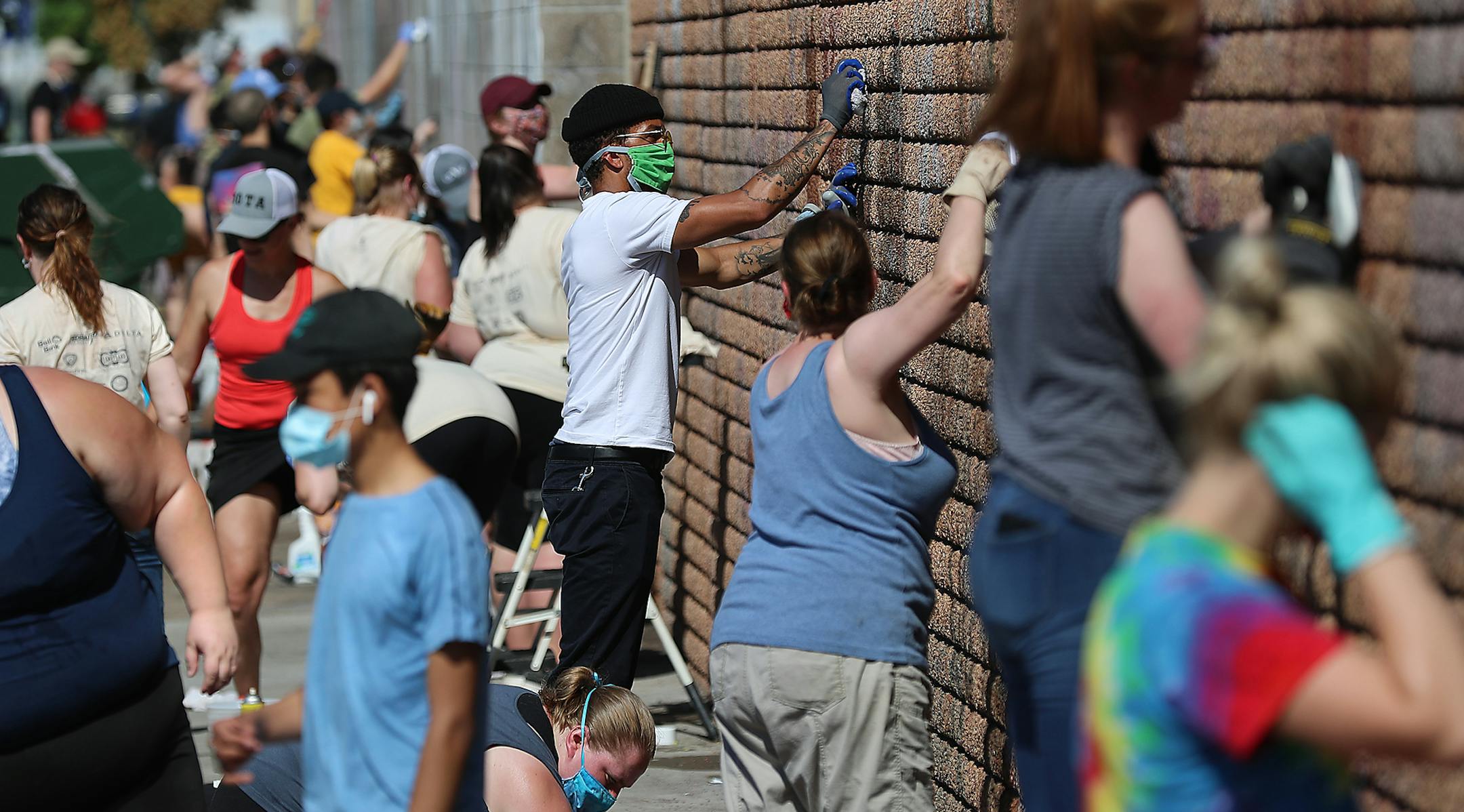 Adam Witherspoon, center, joined dozens of volunteers working to remove graffiti from the Universal Academy Charter School and to clean up on 28th Ave. near Lake Street. Numerous buildings were vandalized and some burned down last week during several nights of unrest in the wake of the George Floyd death in police custody last week and seen Tuesday, June 2, 2020, in Minneapolis, MN. "It was hard sitting on the periphery," said Witherspoon, who expressed gratitude to be able to help the cleanup e
