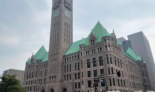FILE - Cars drive past Minneapolis City Hall, June 28, 2023, in Minnesota. Minneapolis City Council members narrowly passed a measure on Thursday, Aug