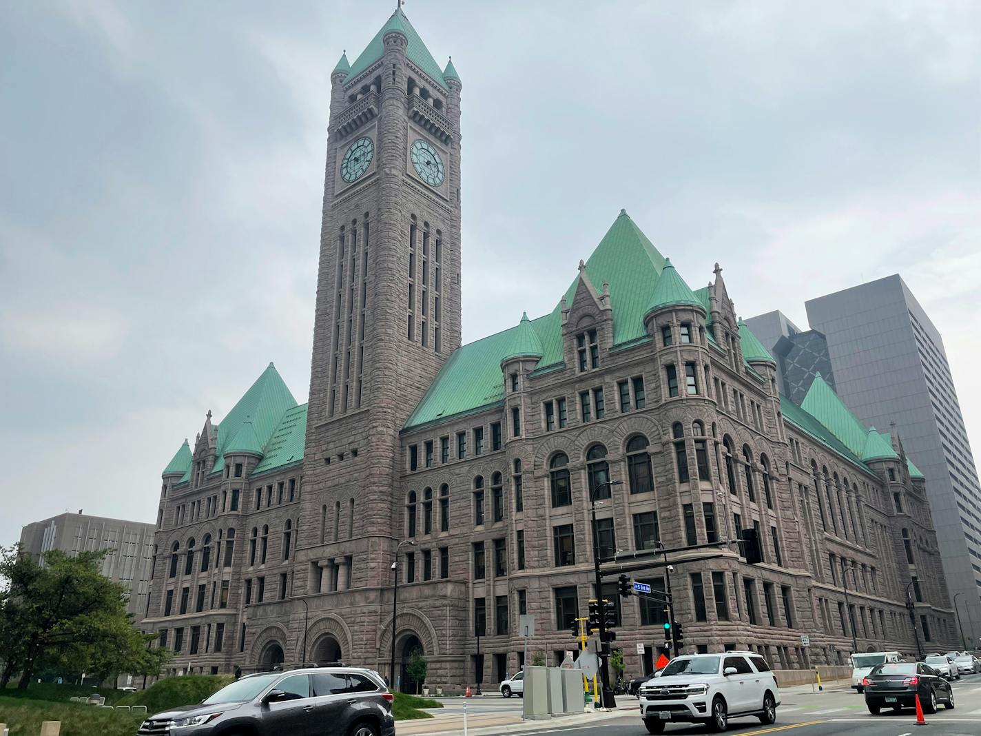 FILE - Cars drive past Minneapolis City Hall, June 28, 2023, in Minnesota. Minneapolis City Council members narrowly passed a measure on Thursday, Aug. 17, that would establish a minimum wage for drivers of Uber, Lyft and other ride-share companies in the city. (AP Photo/Trisha Ahmed, File)