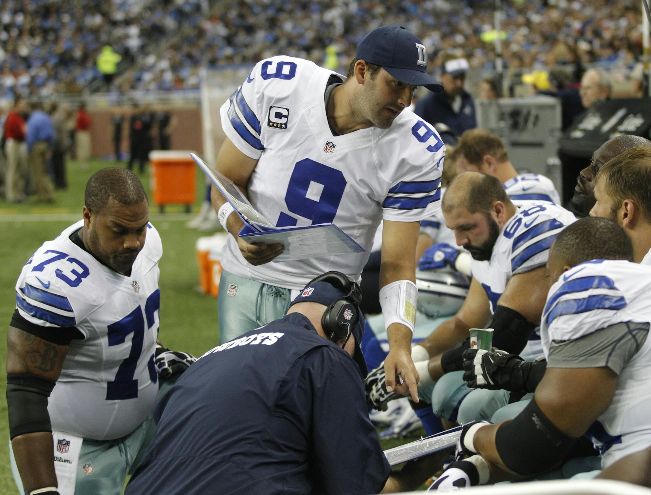 Dallas Cowboys quarterback Tony Romo (9) talks with his teammates during the first half of an NFL football game against the Dallas Cowboys in Detroit, Sunday, Oct. 27, 2013. (AP Photo/Duane Burleson)