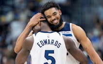 Anthony Edwards (5) of the Minnesota Timberwolves hugs Karl-Anthony Towns late in the fourth quarter on Monday at Ball Arena in Denver.