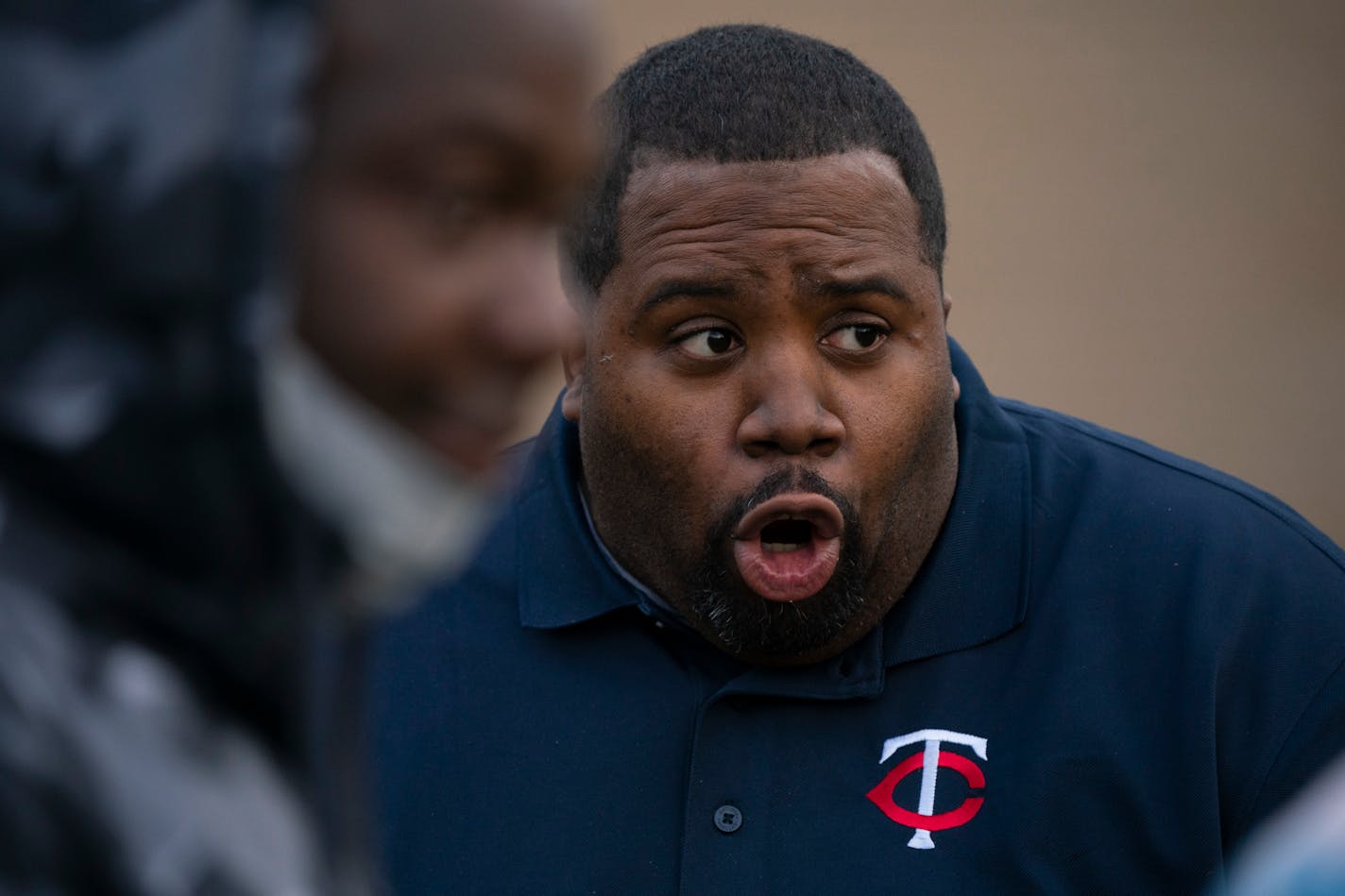 North High School head football coach Charles Adams shown addressing the team at the end of practice while wearing a Twins shirt.