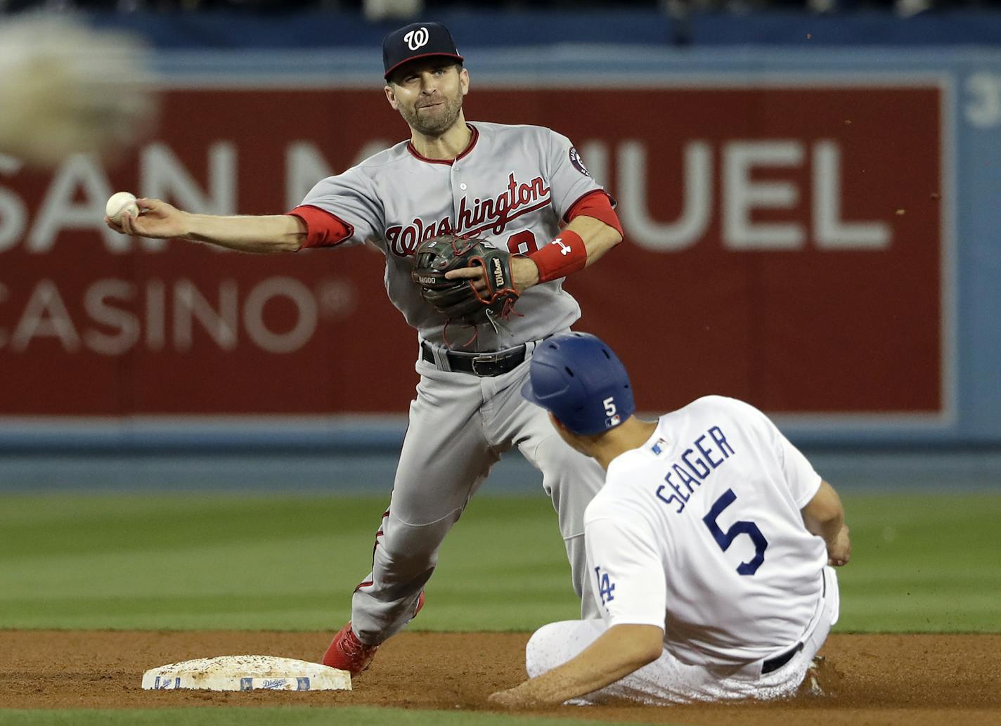 Washington Nationals second baseman Brian Dozier, top, completes a double play over Los Angeles Dodgers' Corey Seager after a ground ball from Chris Taylor during the fourth inning of a baseball game Thursday, May 9, 2019, in Los Angeles. (AP Photo/Marcio Jose Sanchez)