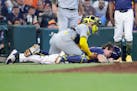 Brewers catcher William Contreras, left, lands on top of Astros runner Jake Meyers after Meyers was tagged out during the seventh inning Sunday.
