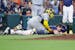 Milwaukee Brewers catcher William Contreras, left, lands on top of Houston Astros runner Jake Meyers, right, after Meyers was tagged out on a pickle p